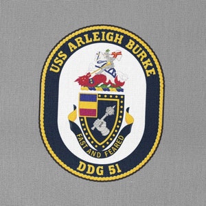 May include: A navy blue and gold oval patch with the text "USS ARLEIGH BURKE" and "DDG 51". The patch features a crest with a red lion, a gold crown, and a shield with a blue and gold design. The text "FAST AND FEARED" is written below the crest.