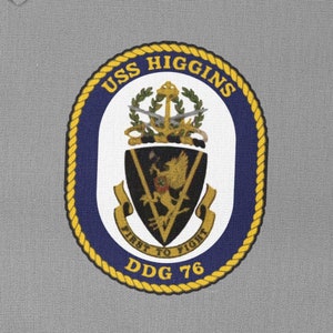 May include: A navy blue and gold embroidered patch with the text "USS HIGGINS DDG 76" and the words "FIRST TO FIGHT" in a banner. The patch features a shield with a lion and a sword.