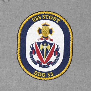 May include: A navy blue and gold embroidered patch with the words "USS STOUT" and "DDG 55". The patch features a crest with a lion, a sword, and the words "Courage, Valor, Integrity".