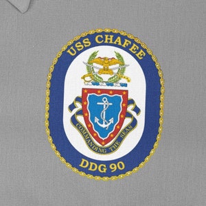 May include: A navy blue patch with a gold chain border and the text "USS CHAFEE DDG 90". The patch features a crest with a gold eagle, a blue shield with a gold anchor, and the text "COMMANDING THE SEAS".