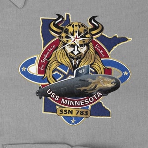 May include: A navy blue patch with a white outline of the state of Minnesota. A Viking with a horned helmet and a beard is in the center of the patch. A submarine with the text "USS Minnesota SSN 783" is below the Viking. The text "Ex Septentrio Virtus" is on the left side of the Viking and the text "783" is on the submarine.