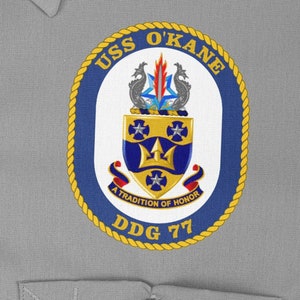 May include: A navy blue and gold embroidered patch with the text "USS O'KANE DDG 77" and the words "A Tradition of Honour" in a banner below a crest with a trident and stars.
