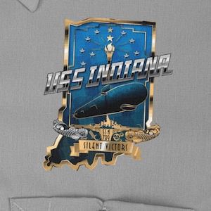 Può includere: Una toppa dorata e blu con il testo "USS INDIANA" e "SILENT VICTORS" in uno stendardo dorato. La toppa presenta un sottomarino e un contorno dello stato dell'Indiana.