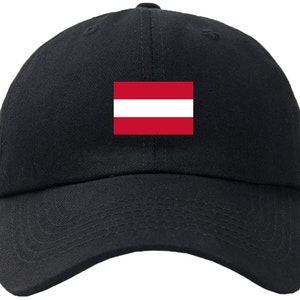 May include: A black baseball cap with the flag of Austria embroidered on the front. The flag is red, white, and red.