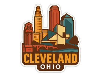 May include: A sticker featuring a stylized illustration of the Cleveland, Ohio skyline. The design includes various buildings in shades of orange, yellow, and blue, with the city name and state abbreviation in a brown banner.