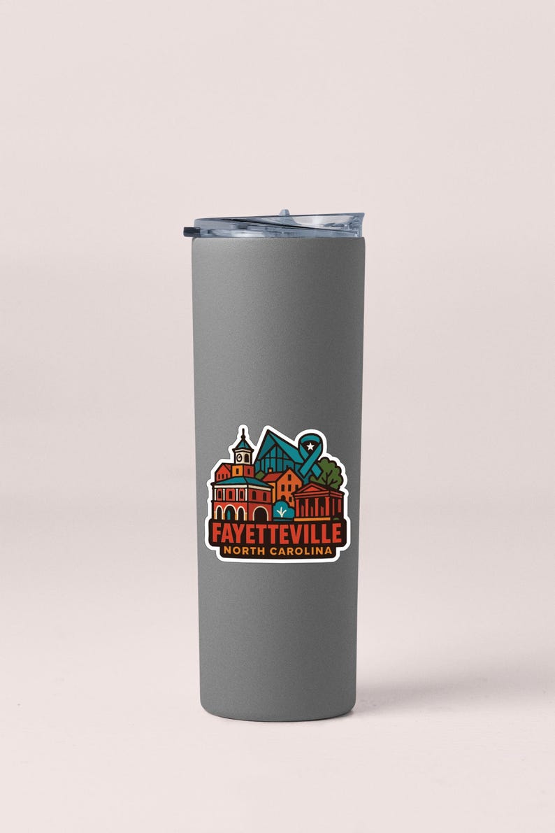 A gray insulated tumbler with a colorful sticker depicting the town of Fayetteville, North Carolina.