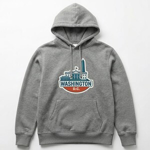 May include: Gray hooded sweatshirt with a front pocket and a drawstring. The sweatshirt features a graphic of Washington D.C. landmarks with the text "WASHINGTON D.C." in a white, red, and green design.