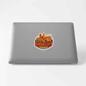 a sticker with the text "KANSAS CITY MISSOURI" on a grey laptop.