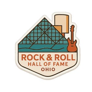 Op de afbeelding: Een sticker met de Rock & Roll Hall of Fame in Ohio. Het ontwerp bevat een turquoise en bruine piramide, een gitaar en de tekst "ROCK & ROLL HALL OF FAME OHIO" in retrostijl.