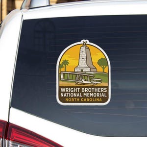 a sticker on the rear window of a vehicle, depicting a monument or memorial.