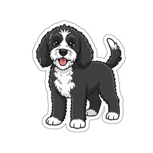 Pode incluir: Um autocolante com uma ilustração de desenho animado de um cão preto e branco com uma expressão feliz. O cão tem uma mancha branca na testa, peito e patas, com a língua rosa. O cão está de pé sobre as quatro patas.