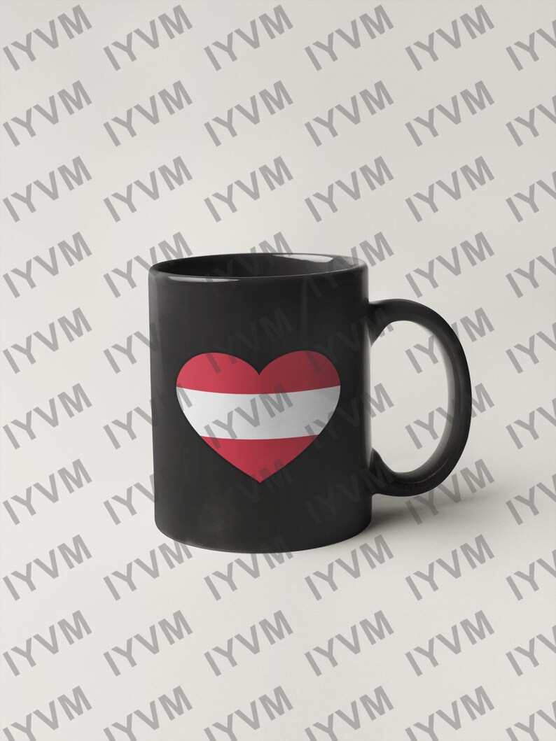 May include: Black ceramic coffee mug with a white heart featuring the Austrian flag. The mug has a white handle.