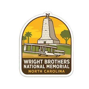 a sticker or emblem with a tall tower and a biplane, representing the Wright Brothers National Memorial in North Carolina.
