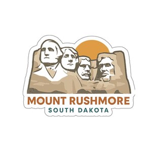 May include: A sticker featuring Mount Rushmore with a tan and brown color scheme, and a yellow sun in the background. The text "MOUNT RUSHMORE SOUTH DAKOTA" is displayed below the monument.