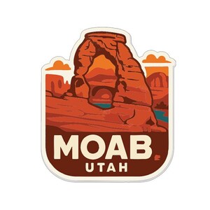 Puede incluir: Una pegatina con una ilustración estilizada de Delicate Arch en Moab, Utah. El diseño muestra el arco en tonos naranja y rojo, con un río azul y el texto "MOAB UTAH" en negrita.