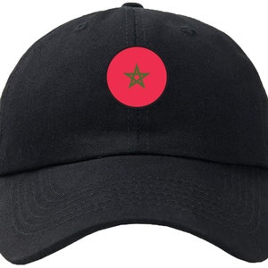 May include: A black baseball cap with a red circle and a green five-pointed star in the center.