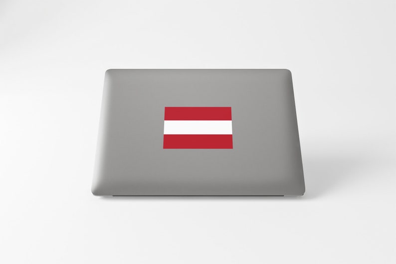 K&ouml;nnte beinhalten: Ein grauer Laptop mit einem roten und wei&szlig;en &ouml;sterreichischen Flaggenaufkleber auf der R&uuml;ckseite.