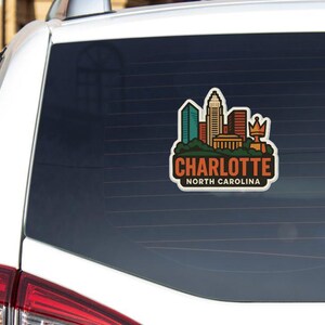 A sticker on the rear window of a car that says "Charlotte North Carolina".