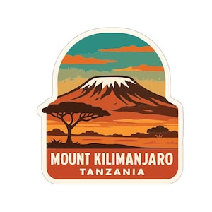 May include: A sticker depicting Mount Kilimanjaro in Tanzania. The image shows a snow-covered mountain, a tree, and a sunset in orange, brown, and teal hues. The text "MOUNT KILIMANJARO TANZANIA" is displayed in a bold font.