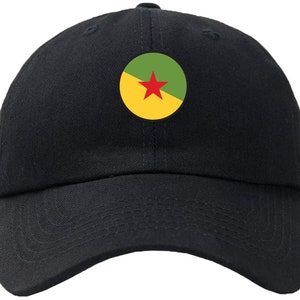 May include: Black baseball cap with a circular emblem featuring a red star on a green and yellow background. The cap has a curved brim and an adjustable strap at the back. The hat is made of a durable fabric.