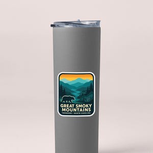 A gray insulated tumbler with a sticker featuring a mountain landscape and the text "Great Smoky Mountains National Park, Tennessee, North Carolina".