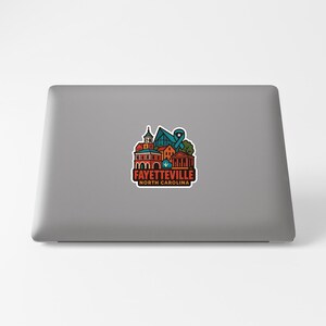a sticker with a colorful illustration of a city skyline, representing the city of Fayetteville, North Carolina.