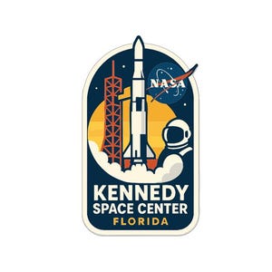 May include: A navy blue and white patch featuring a rocket, launch tower, and astronaut, with the NASA logo and the text "KENNEDY SPACE CENTER FLORIDA". The design is set against a yellow and dark blue background.