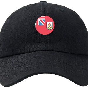 May include: A black baseball cap with a red, white and blue circular patch featuring the flag of Bermuda.