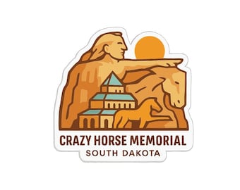 May include: A sticker featuring the Crazy Horse Memorial in South Dakota. The design includes a depiction of Crazy Horse, a horse, and a building, all in shades of brown and orange, with a yellow sun in the background. The text "Crazy Horse Memorial South Dakota" is at the bottom.