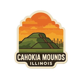 Op de afbeelding: Een sticker met de Cahokia Mounds in Illinois. Het ontwerp bevat een groene heuvel met een houten trap, tegen een oranje zonsonderganghemel. De tekst "CAHOKIA MOUNDS ILLINOIS" wordt in witte letters op een donkere achtergrond weergegeven.