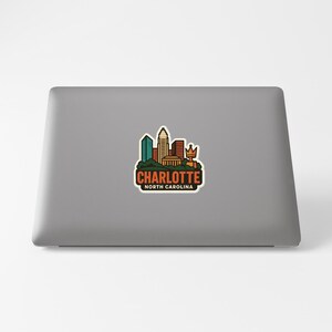 A sticker depicting the skyline of Charlotte, North Carolina, on the back of a laptop computer.