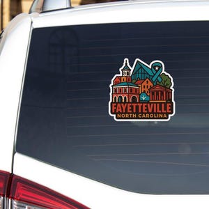 A sticker on the rear window of a white car, featuring an illustration of a city skyline with various buildings and landmarks.
