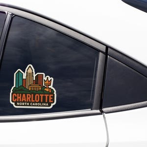 A sticker on the side of a car window that says "CHARLOTTE NORTH CAROLINA".