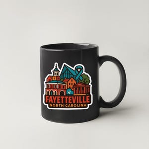 A black coffee mug with a colorful graphic design depicting the town of Fayetteville, North Carolina.