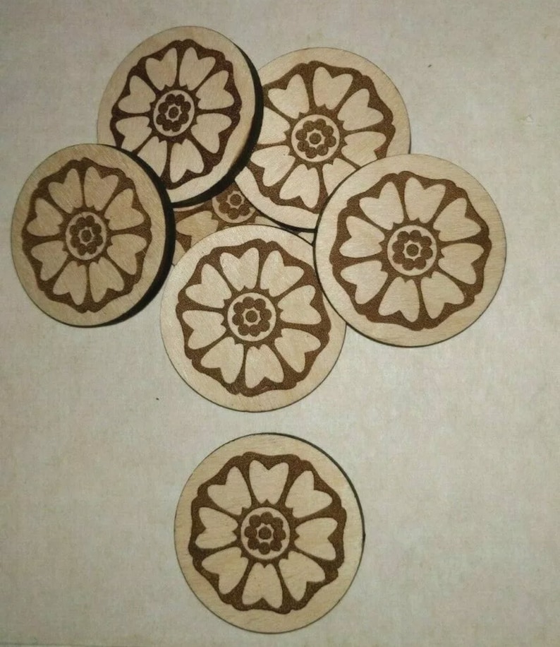 Peut inclure: Ensemble de dessous de verre en bois avec un motif floral grav&eacute; au laser. Les dessous de verre sont ronds, de couleur bois clair et pr&eacute;sentent un motif floral brun plus fonc&eacute;. Le motif pr&eacute;sente un cercle central entour&eacute; de p&eacute;tales en forme de c&oelig;ur.