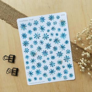 Könnte beinhalten: Eine Blatt mit Aufklebern mit blauen und weißen Aquarell-Schneeflocken. Das Blatt ist mit "Snowflakes - small" und "#008" beschriftet.