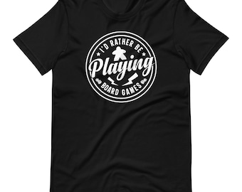 Könnte beinhalten: Schwarzes T-Shirt mit einem weißen Kreis-Motiv, auf dem "I'd Rather Be Playing Board Games" steht. Das Motiv zeigt eine weiße Spielfigur und Blitze.