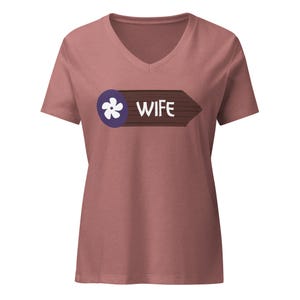 May include: A maroon v-neck t-shirt with a graphic of a wooden sign that says "WIFE" with a purple flower icon.