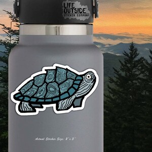 May include: A blue and black turtle sticker with a detailed shell design. The sticker is 2 inches by 3 inches and is on a gray water bottle. The sticker is from Life Outside Sticker Company.