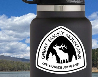 May include: A black water bottle with a white sticker featuring a silhouette of an elk and trees, with the text "Great Smoky Mountains" and "Life Outside Approved." The sticker is approximately 3 inches by 3 inches.