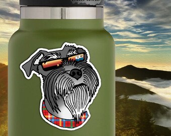 May include: A sticker of a gray schnauzer dog wearing sunglasses with a red, blue, and yellow plaid bandana. The sticker is 2.5 inches by 2.5 inches. The text "Life Outside Sticker Company" is in the top right corner of the sticker.