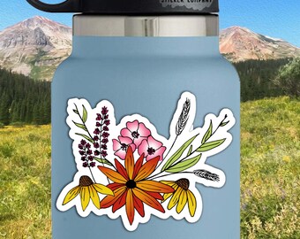 May include: A sticker featuring a colorful bouquet of flowers with pink, red, orange, yellow, and green hues. The sticker is 2.5 inches by 3 inches and is on a blue water bottle.