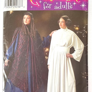 May include: Simplicity pattern 0577 for adult costumes. The pattern includes two costumes: a long, dark purple and black gown with a high collar and a long, white gown with a high collar and long sleeves. The pattern is for sizes 14, 16, 18, and 20.