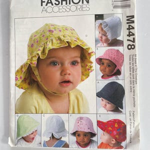 May include: A sewing pattern for making baby sun hats. The pattern includes instructions for making six different styles of hats, including a sunbonnet, a bucket hat, and a baseball cap. The pattern is for sizes newborn to 24 months.