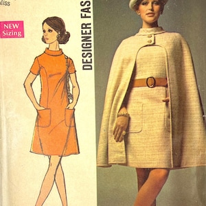 May include: Vintage Simplicity Designer Fashion sewing pattern. The cover features illustrations of two women's outfits: an orange dress and a beige cape dress. The text includes "New Sizing" and "Designer Fashion".
