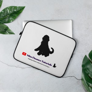 以下が含まれることがあります： 白いノートパソコンのスリーブで、黒い犬のシルエットが描かれています。スリーブには「Miss Finance Tutorials」というテキストとYouTubeのロゴが書かれています。下のテキストには「Helping students understand accounting x」と書いてあります。