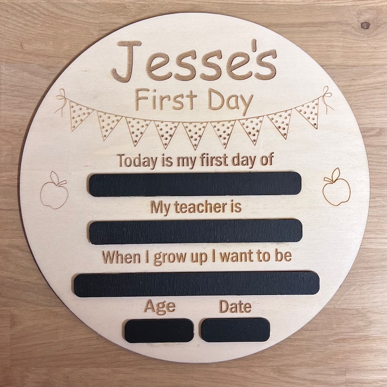 Pu&ograve; includere: Un cartello di legno con il testo "Jesse's First Day" e spazi da riempire con informazioni sul primo giorno di scuola del bambino, tra cui la data, l'et&agrave;, il nome dell'insegnante e cosa vuole fare da grande.