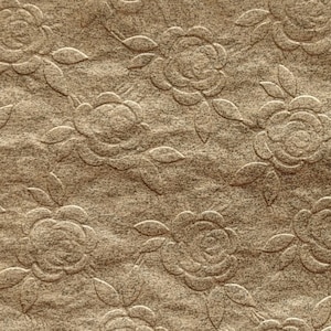 May include: A brown paper napkin with a raised embossed pattern of roses. The napkin is 4 inches wide and 4 inches long.