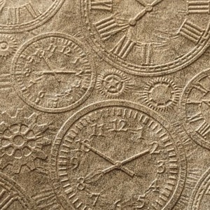 May include: A brown paper sheet with a repeating pattern of embossed clock faces. The clocks are in various sizes and have Roman numeral markings.