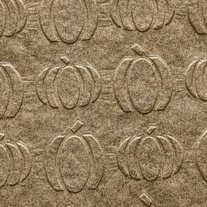 May include: A sheet of brown paper with a repeating pattern of embossed pumpkins. The paper is approximately 4 inches wide.